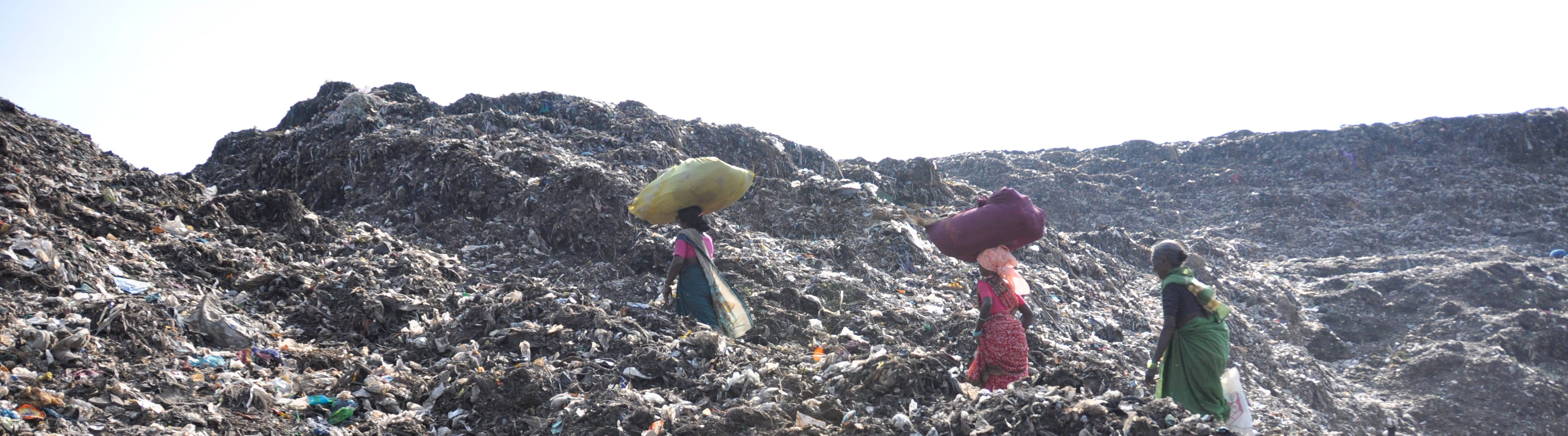 Waste picker of KKPKP with her sack of recyclables at the Uruli landfill, KKPKP