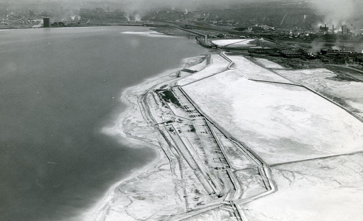 Aerial photograph of the western shore of Onondaga Lake during the mid-20th century. https://www.americanindianmagazine.org/story/saving-a-sacred-lake Aerial photograph of the western shore of Onondaga Lake during the mid-20th century. https://www.americanindianmagazine.org/story/saving-a-sacred-lake
