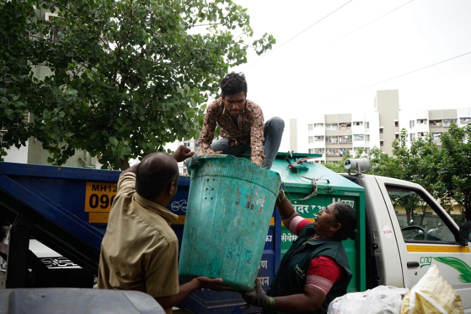 Baida Gaikwad from KKPKP/SWaCH handing over organic waste to the Municipal truck, VIdya Kulkarni.