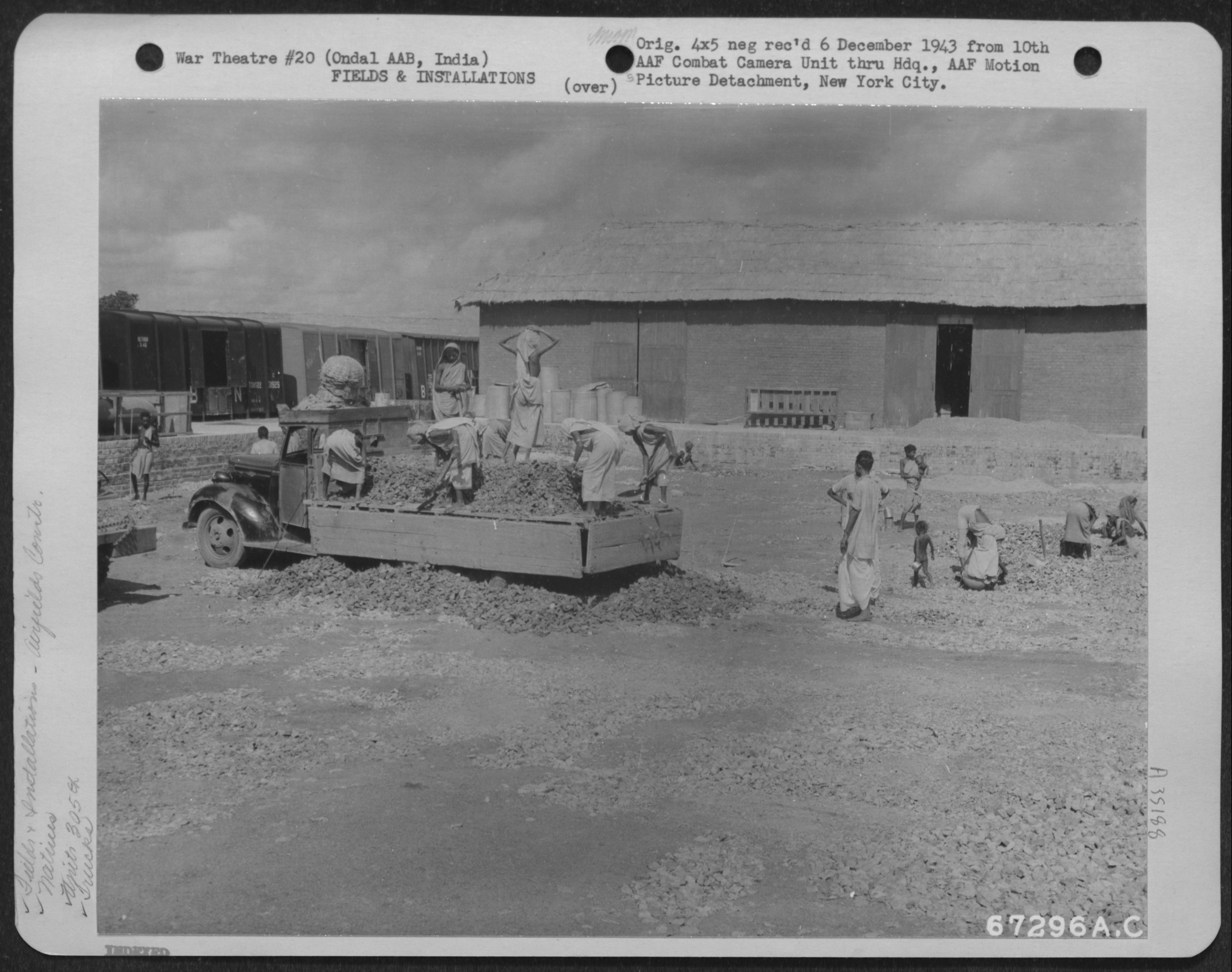 Workers loading a truck with crushed stone, Ondal, 1943. 'Natives dump a truck load of crushed stone on the warehouse yard at Ondal AAB in India. The work is under the supervision of the 305th Service Group, 1943.' NARA, Record Group 342, 342-FH-3A35188-67296AC.