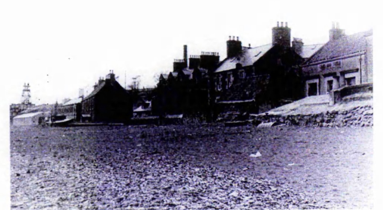 East Wemyss in 1951. The beach, by this date, has been submerged beneath a blanket of colliery waste. Note how the large seawall to the left, is now merely a ‘step’ away from the beach. The steps leading to the door in the wall have also been completely covered in sediment. The colliery waste appears to have grown to over 3m in depth indicated by the complete submergence of the seawall to the left of the image where previously (in Plate 2.12) people were standing. From: Elisabeth Saiu, 'Mining subsidence: its effects on the south-east Fife coastline' (unpublished PhD dissertation, University of St Andrews, 1998, available at https://research-repository.st-andrews.ac.uk/handle/10023/15553 ).