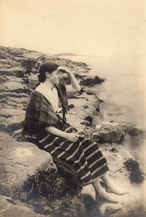 Black & white photograph of a young woman, thought to be Catherine MacKenzie (nee MacFarlane of Baugh Manse, 1864-1904), sitting at the shore in around 1885. Catherine was the daughter of Rev Duncan MacFarlane, Baptist minister at Baugh. Catherine married Duncan MacKenzie of Inverary, but left him around 1904 and returned to live with her parents at Baugh Manse, where she remained until her death. One of her sons, Kenneth MacKenzie, became Chief Officer aboard the ship ‘Discovery‘. An Iodhlann.