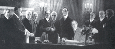 President Woodrow Wilson signs the 1913 Federal Reserve Act, establishing the Federal Reserve System. 