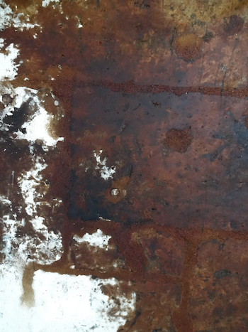 The rust-stained wall in the old paper mill that is now the Musée du Papier.